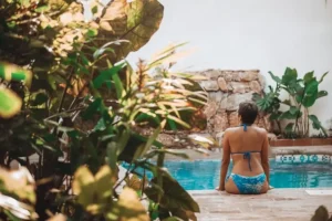 Guest extends gracefully in floating-yoga pose amid tropical greenery — a calm moment within a restorative retreat shaped for harmony.