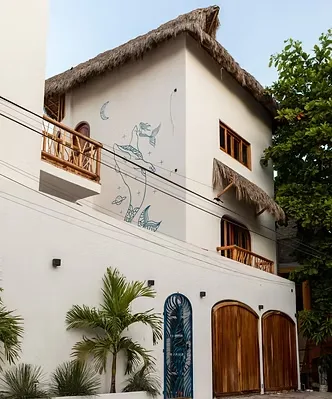 Whale mural and palapa roof welcomes guests to an eco-aware coastal haven — among the premium Sayulita resorts for mindful travelers.