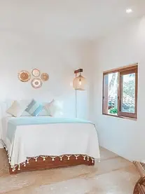 Elevated design beds and Oaxacan textiles define a premium north-end suite on Mexico’s Pacific coast, balancing comfort and style.