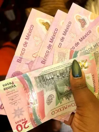 Traveler exchanges pesos on a sunny Sayulita street — proof that conscious travel Sayulita stays effortless, friendly, and warmly local.