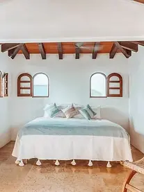 Villa Ama Studio features a king bed with craft-made linens and a beamed ceiling — a leading choice among Sayulita Mexico hotels.