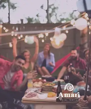 Amigos celebran bajo luces colgantes en Amari — un hotel boutique en Nayarit, México, donde el diseño y la calidez inspiran viajes en grupo.