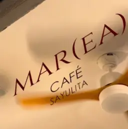 El logotipo de Marea Café aparece en un techo de tonos cálidos que refleja el carácter costero y relajado de este acogedor café de Sayulita.