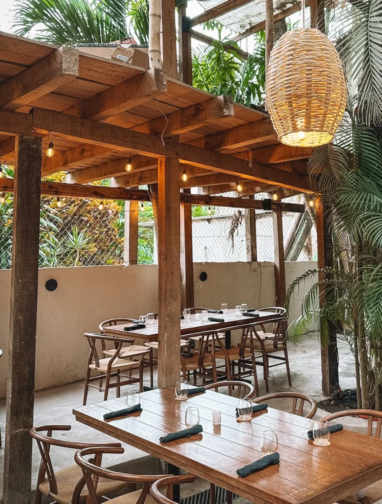 La luz ámbar y mesas rodeadas de palmeras crean una escena mediterránea en The Embers, un restaurante muy querido en Sayulita.