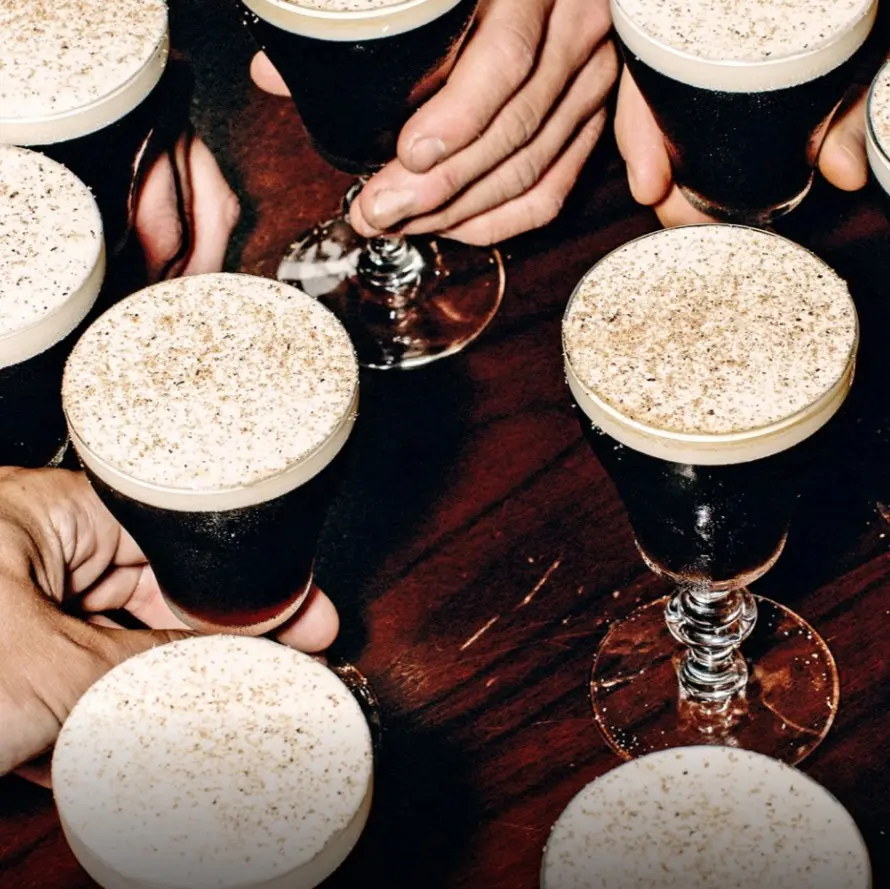 Vasos de café irlandés cubiertos con crema batida capturan el carácter suave de esta mezcla de café caliente, whisky irlandés y dulzura ligera.