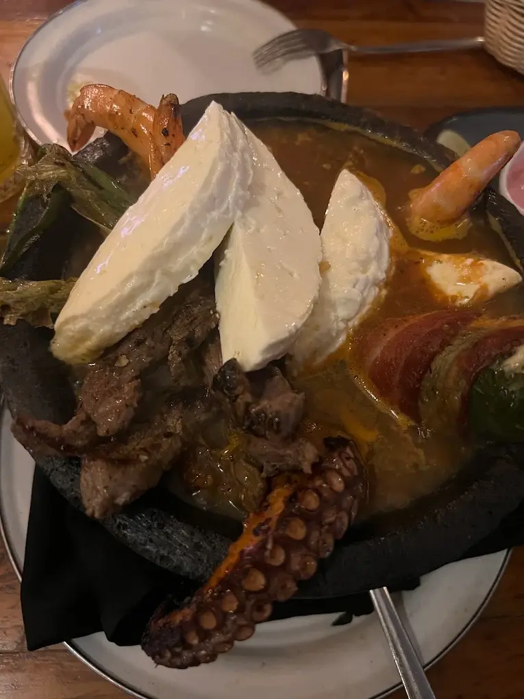 Molcajete at Barracuda with octopus, shrimp, steak, cheese, and vegetables in a rich sauce, known for bold flavors and a shareable coastal mariscos style.