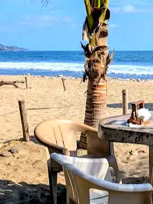 Una mesa exterior con bebidas invita a una pausa tranquila en Bar La Isla, junto al paseo costero de Sayulita.