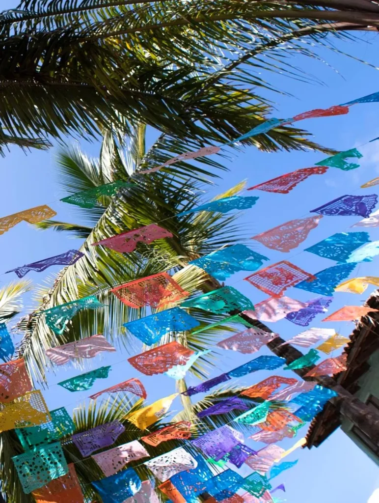 Papel picado flutter over the plaza in the morning breeze, reflecting the region’s cultural spirit across this scenic coastal corridor.