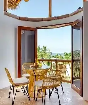 Dining area opens to a balcony with ocean views at Amari, a premier coastal retreat where wellness and slow-living elegance meet.