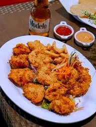 Un plato crujiente y agridulce llega listo para disfrutarse, con sabores intensos en un ambiente relajado.