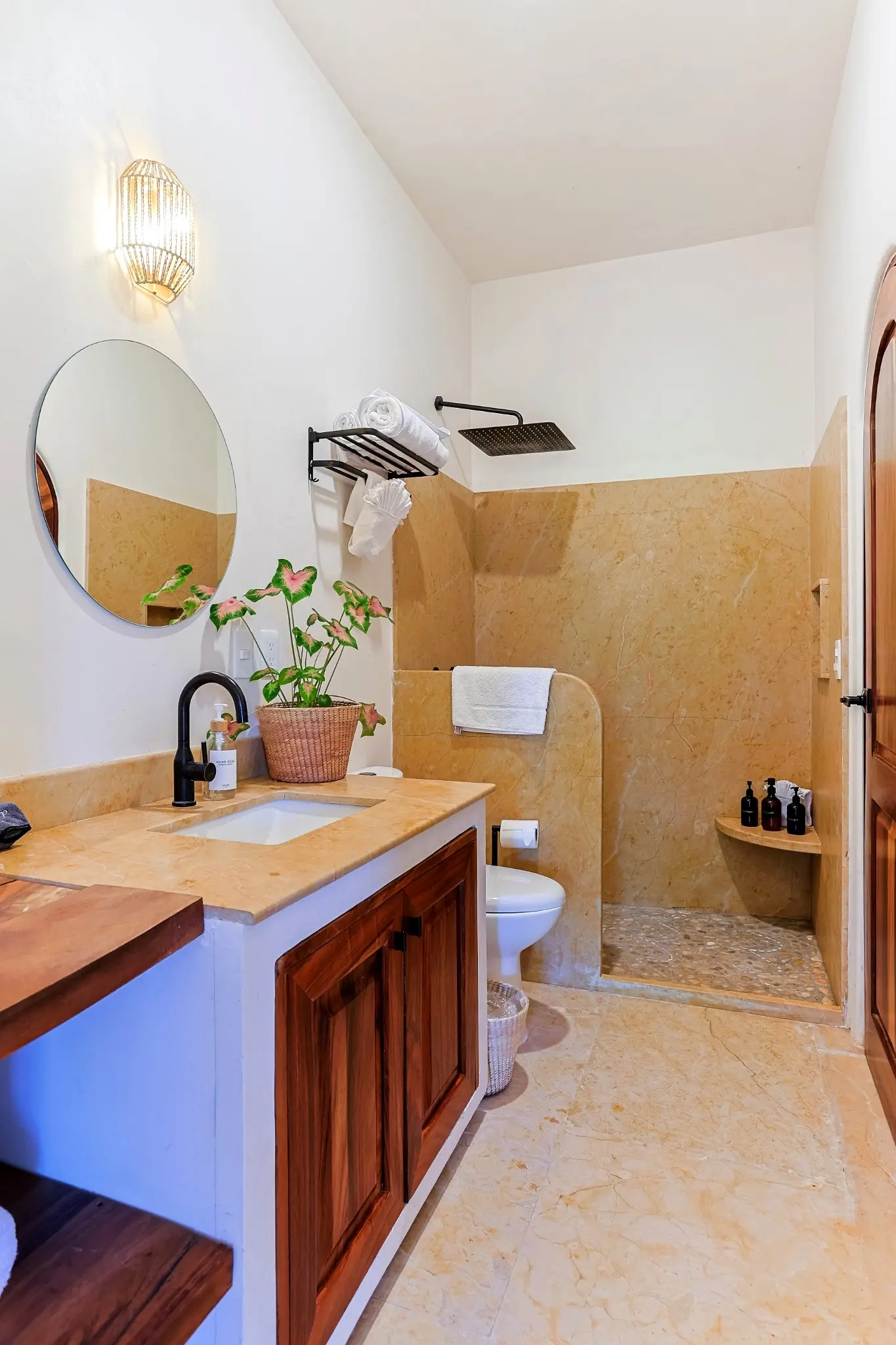 Spacious Bathroom With Rain Shower, Stone Walls, and Vanity Amenities