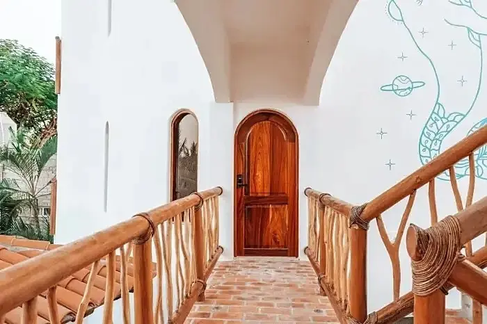 Private Suite Entrance With Arched Wooden Door and Rustic Railings
