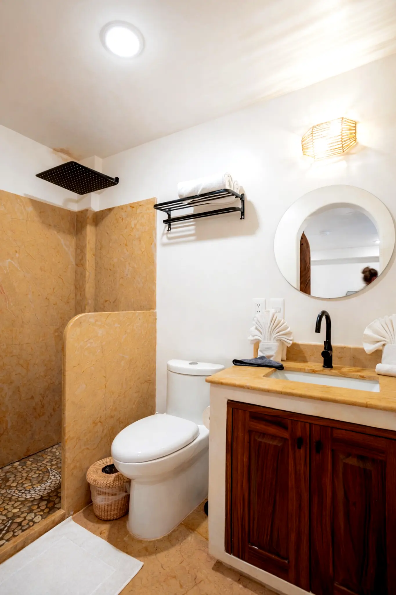Bathroom With Rain Shower, Warm Stone Tile, and Wooden Vanity