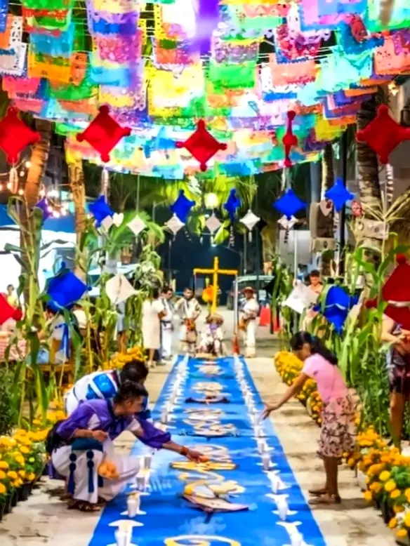 Marigolds and candles line a walkway for Día de los Muertos, their glow marking a path of remembrance as families honor cherished stories.
