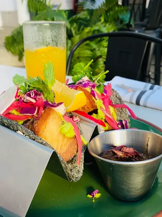 Crispy fish tacos at El Tiburón with avocado sauce, fresh cabbage, citrus garnish, and house salsa, a popular pick for balanced coastal mariscos.