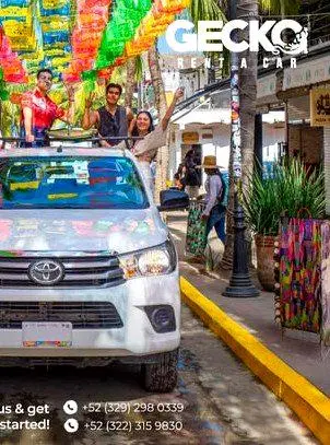 A bright Gecko rental car rolls beneath colorful papel picado, marking the start of an easy travel day for visitors driving north to Sayulita.