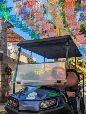 A colorful golf cart glides beneath papel picado, reflecting Sayulita’s playful spirit near a calm retreat on Mexico’s Western Riviera shoreline.