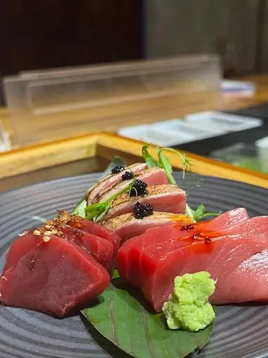 Premium nigiri at Henshin’s omakase bar showcasing fresh salmon and tuna with wasabi, soy, and refined presentation for a high-end sushi experience.