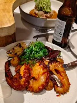 Grilled octopus at La Rustica with roasted potatoes, greens, and house seasoning, known for polished presentation and refined coastal seafood plates.