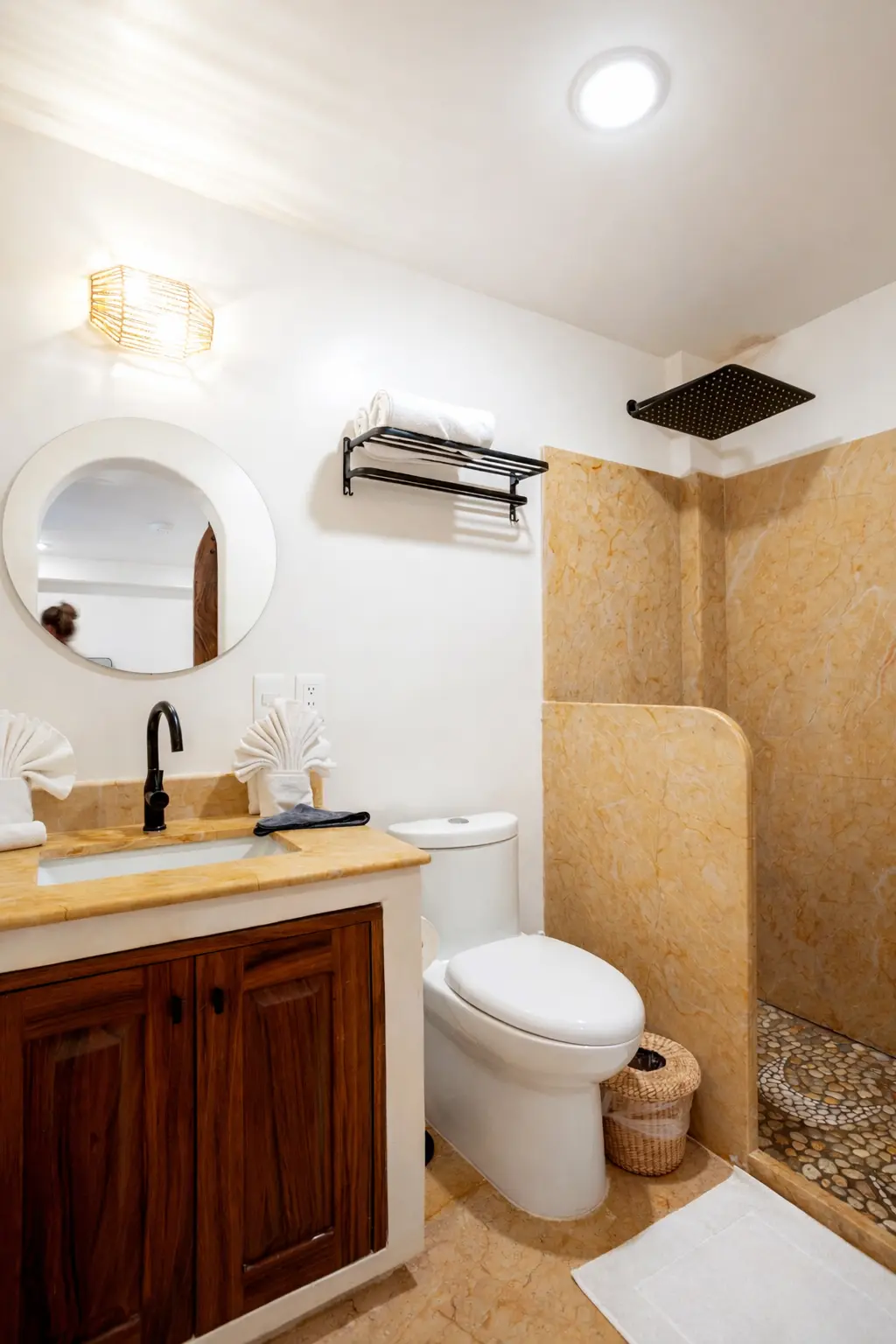 Spa-Style Bathroom With Rain Shower, Golden Stone, and Matte-Black Hardware
