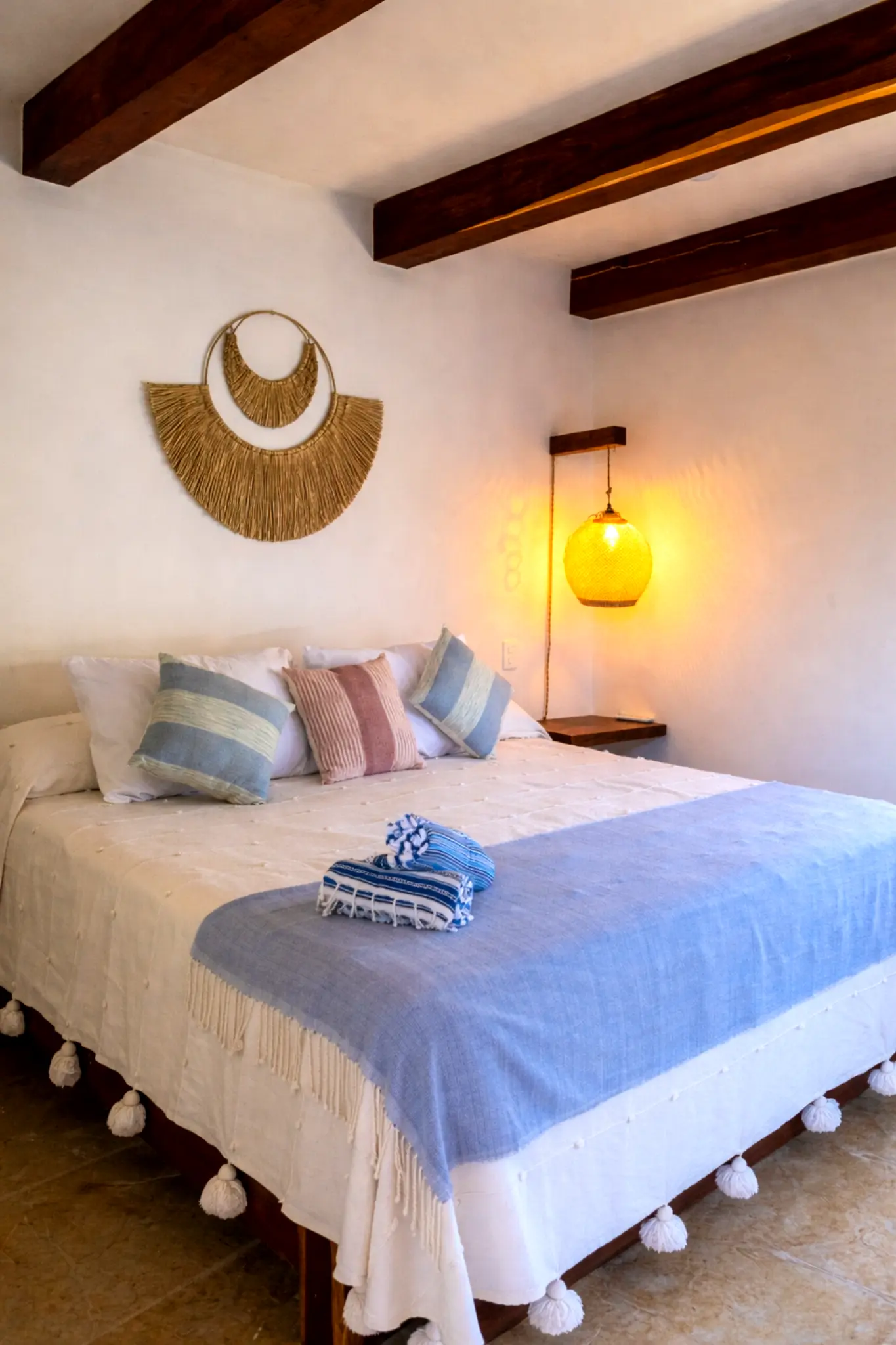 Minimalist Bedroom With Exposed Beams, Woven Sconce, and Tropical Views