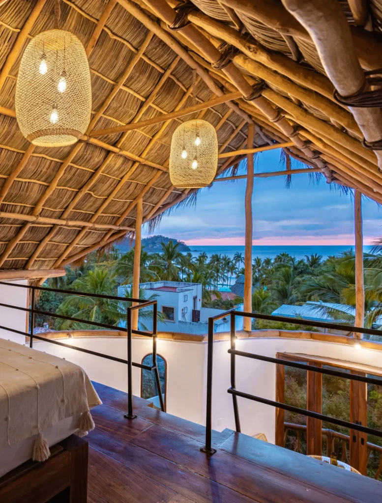 A sunlit palapa suite opens toward wide ocean views at Amari, blending artisan woodwork and gentle light into a warm, serene retreat for guests.