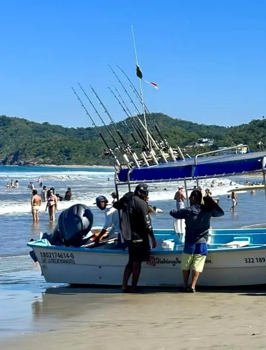 Fishermen prepare to launch a panga at sunrise, a practiced moment of skill and teamwork beginning another coastal workday.