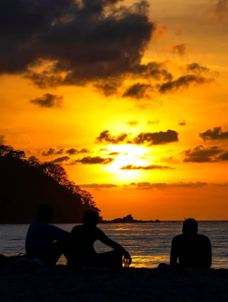 Friends gather by the ocean at sunset in Sayulita, sharing laughter and golden light along the Pacific Coast near a boutique coastal retreat in Riviera Nayarit.