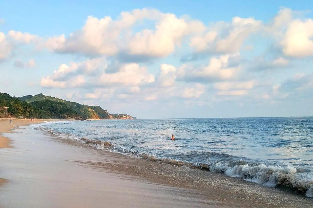 Morning light glows across gentle waves nea an oceanview hotel—a tranquil start to the day along the stunning Riviera Nayarit shoreline.