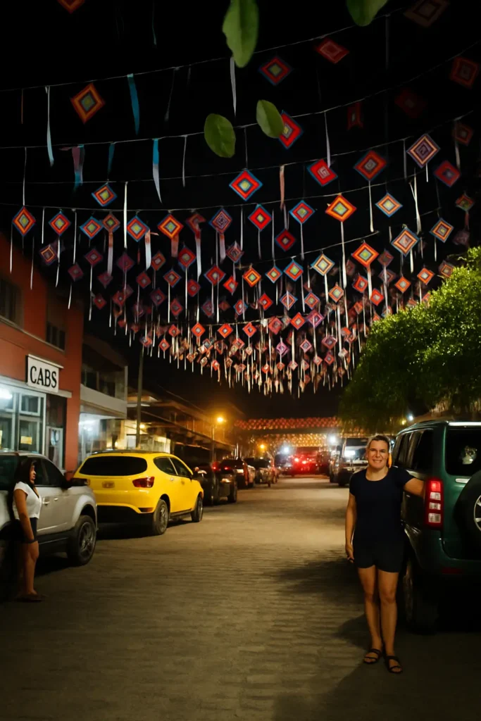 Bright lights and hanging decor illuminate the cobblestones as locals wander home—soft, steady lighting that keeps Sayulita’s evenings feeling safe.
