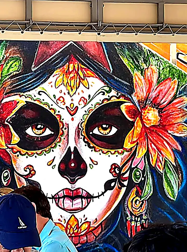 Large Catrina mural with vivid flowers and detailed Día de los Muertos face paint fills a wall, capturing the creative spirit in Nayarit.