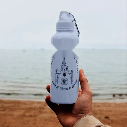 Hand holding a reusable water bottle by the shoreline, a simple eco-friendly essential for warm days in the Nuevo Vallarta area.