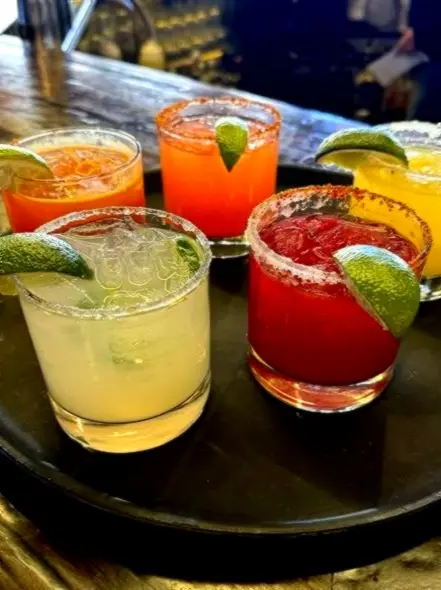 Colorful margaritas with salted rims on a bar tray, bringing bright citrus flavor to relaxed evenings in Riviera Nayarit.