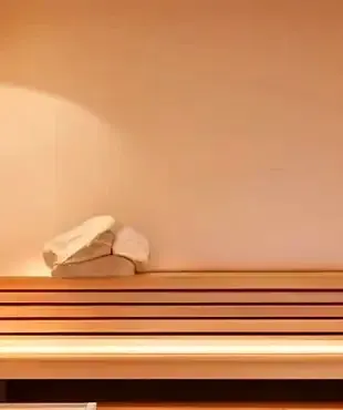 Una cálida luz ámbar ilumina la sauna del exclusivo hotel Amari en Sayulita, invitando a una profunda relajación y a un equilibrio indulgente.