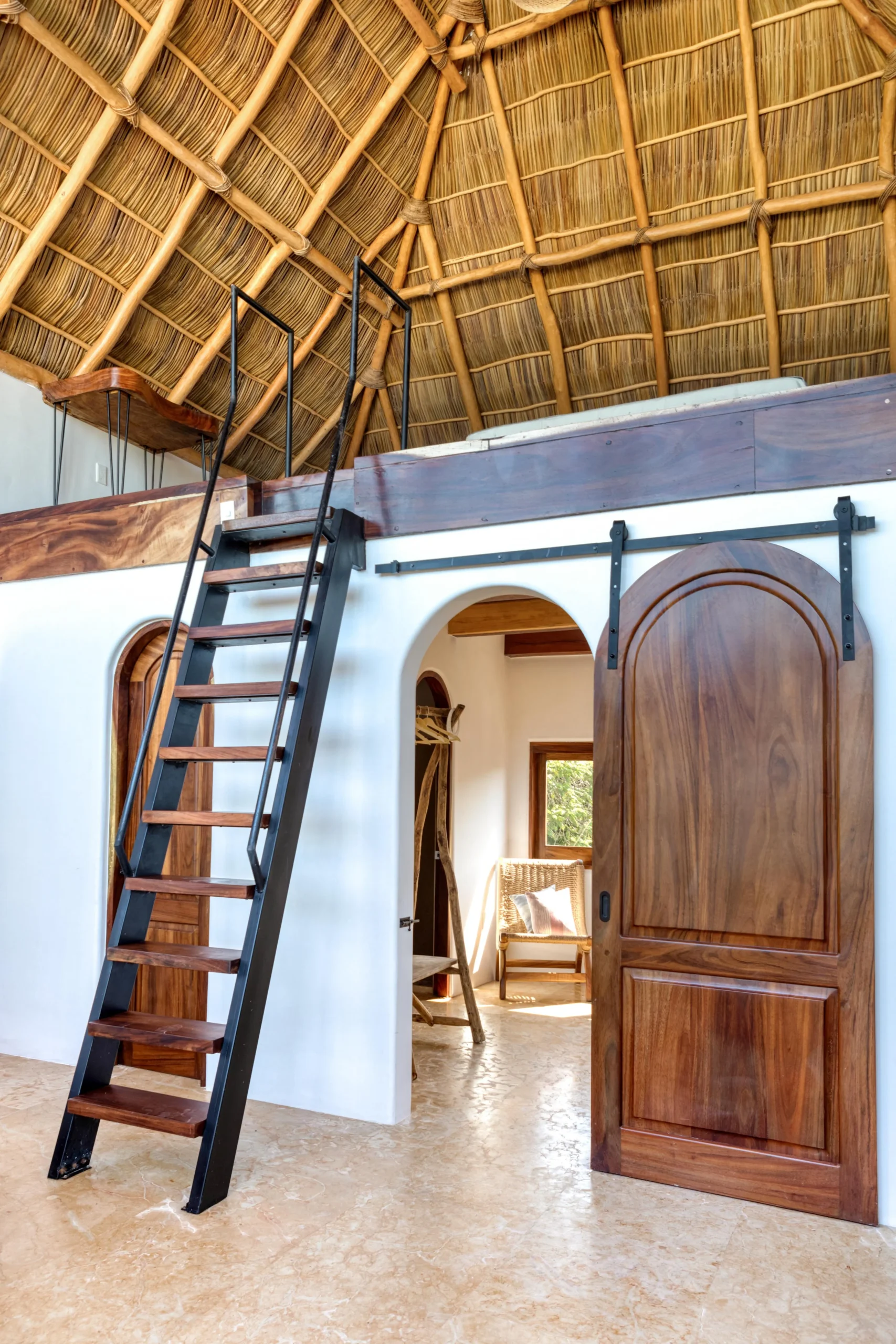 Comfortable suite at Amari with woven seating, smooth plaster walls, and rich wood finishes, located near restaurants known for ceviche, lobster, and grilled mariscos.