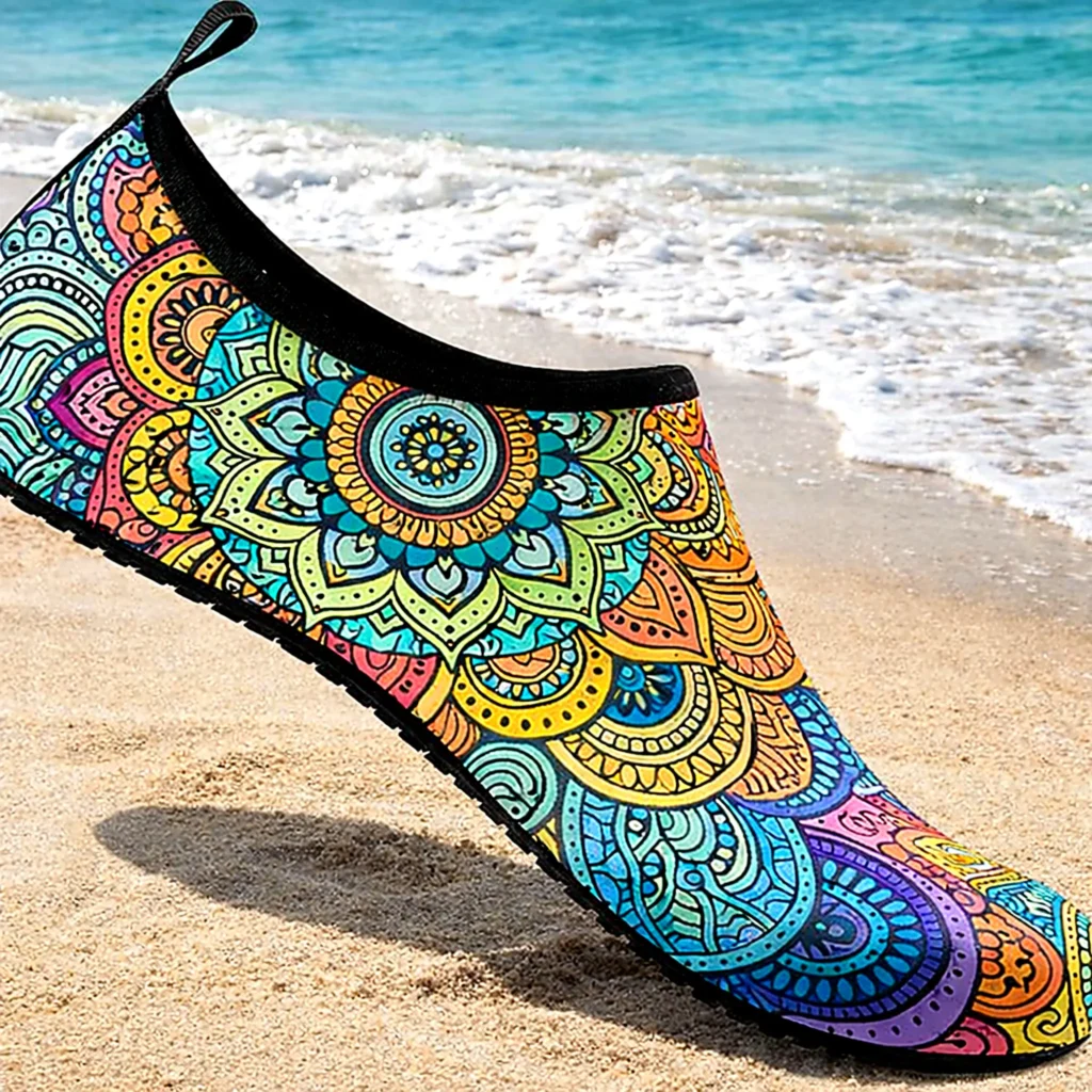 Colorful water shoe on sandy shoreline near gentle surf, a practical pack item for exploring the Bahía de Banderas coastline.