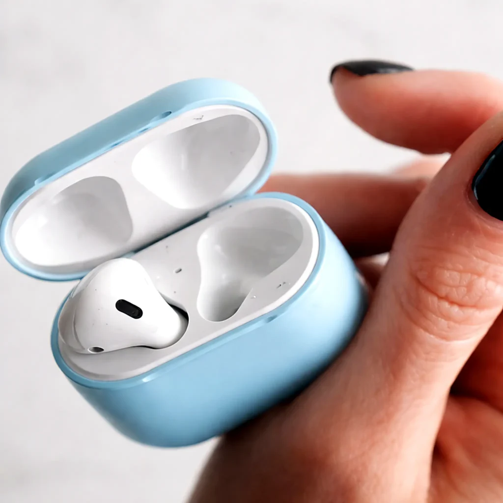 Wireless earbuds in a charging case held in hand, a helpful item for flights, calls, and relaxing playlists during your trip.