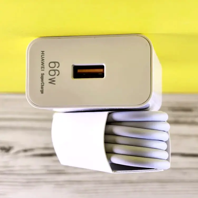 Compact wall charger with coiled charging cable, a simple must-pack item for keeping your devices powered throughout your trip.