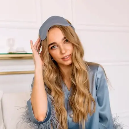 Traveler wearing a soft sleep mask and cozy lounge set, a helpful packing item for flights and restful nights.