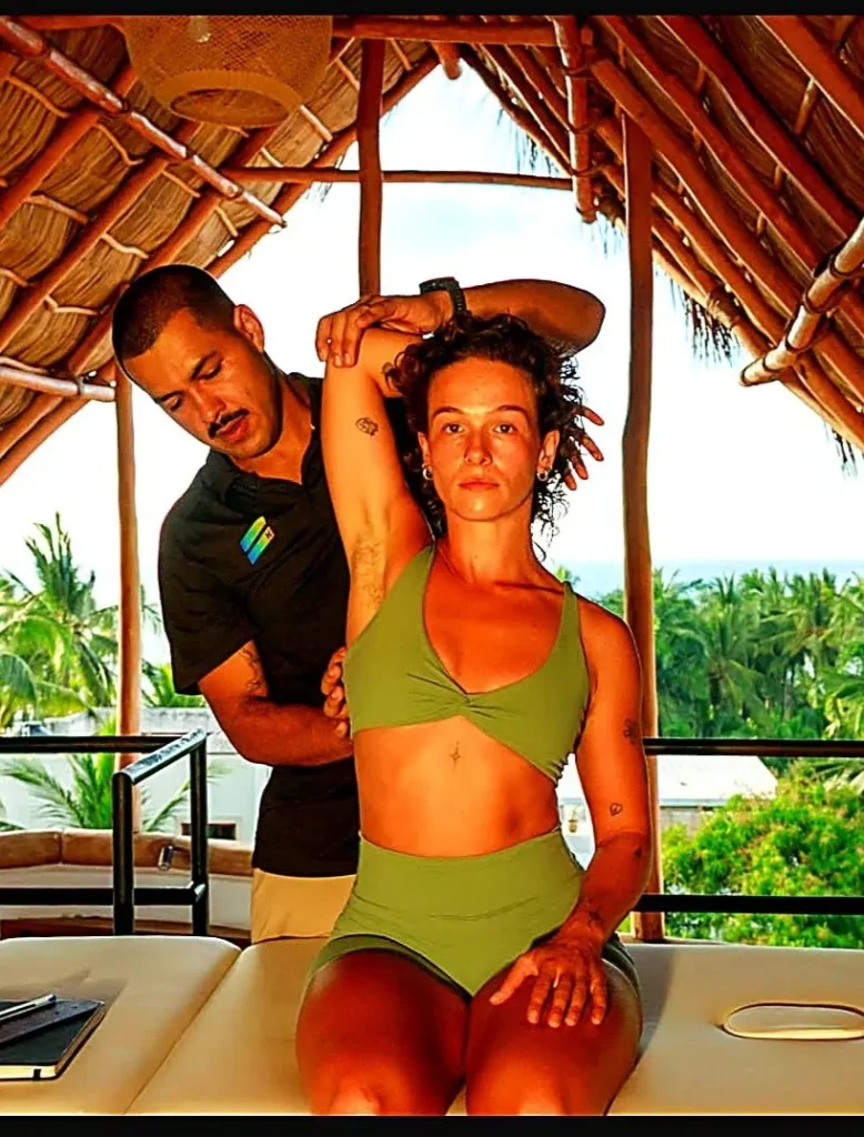 A guest receiving a personalized massage treatment at Amari Boutique Hotel, guided by a skilled therapist in an open-air palapa with tropical views.