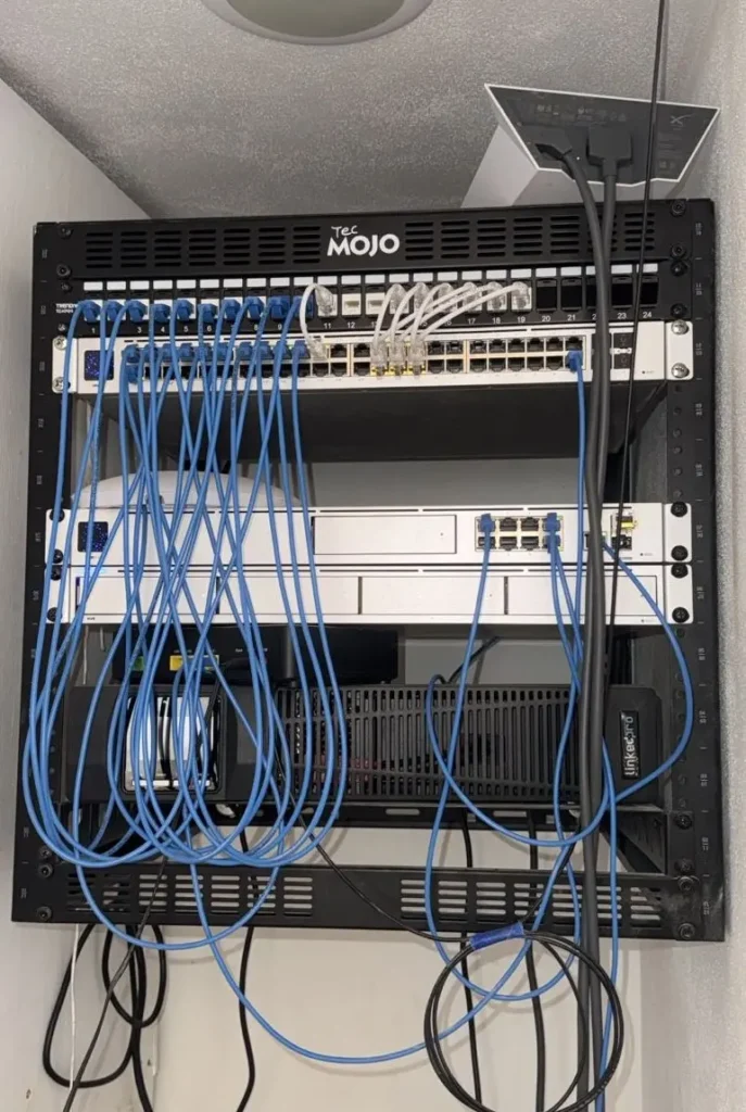 Wall-mounted network rack with UniFi Dream Machine Pro, PoE switches, and Starlink integration supporting stable high-speed internet at Amari.