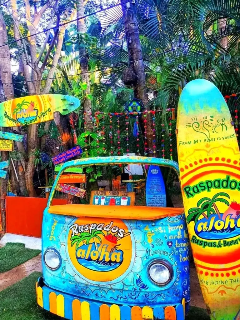 A colorful raspado stand decorated with surfboards and tropical artwork reflects the creative atmosphere of Sayulita, Mexico.
