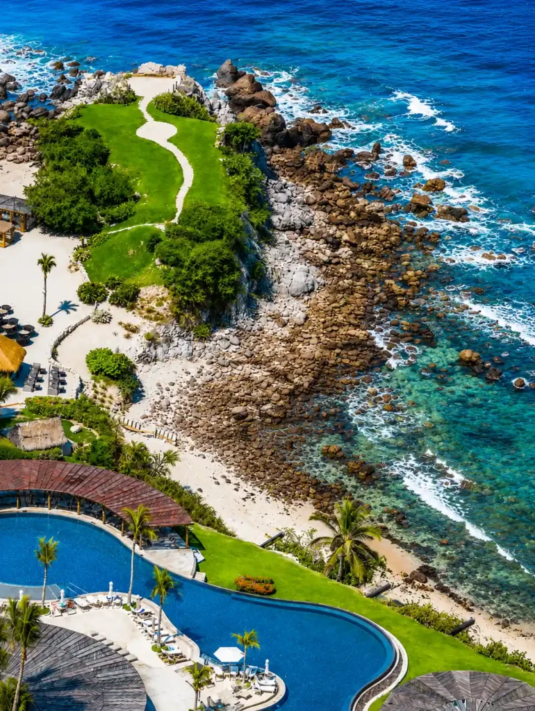 Aerial view of Punta Mita's exclusive coastline featuring luxury resorts, private beaches, dramatic rocky shoreline, and turquoise Pacific water.