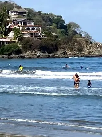 Visitors enjoying the beach below hillside villas on the South Side overlooking Bahía de Banderas.